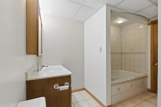 5753 Pluto St, Rapid City, SD 57703 - bathroom with tile patterned flooring, baseboards, vanity, tiled shower / bath, and a drop ceiling