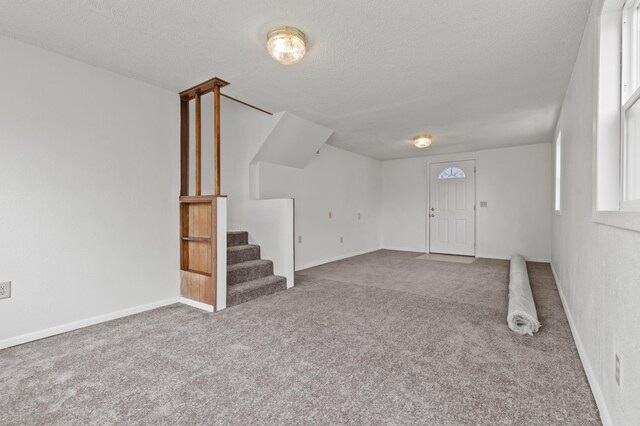 4648 Other, Rapid City, SD 57703 - entryway featuring carpet floors, a textured ceiling, stairs, and baseboards