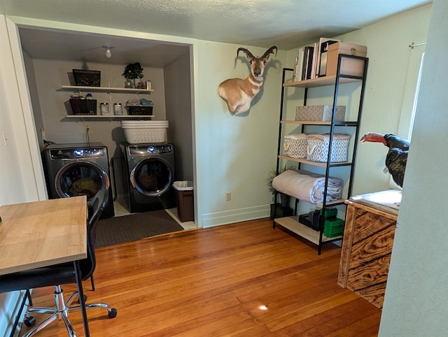 washroom featuring independent washer and dryer, hardwood / wood-style flooring, baseboards, and a desk