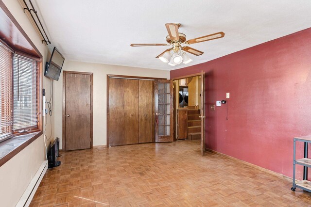 2030 12th Ave, Belle Fourche, SD 57717 - unfurnished bedroom with a baseboard heating unit, baseboards, multiple closets, and a ceiling fan