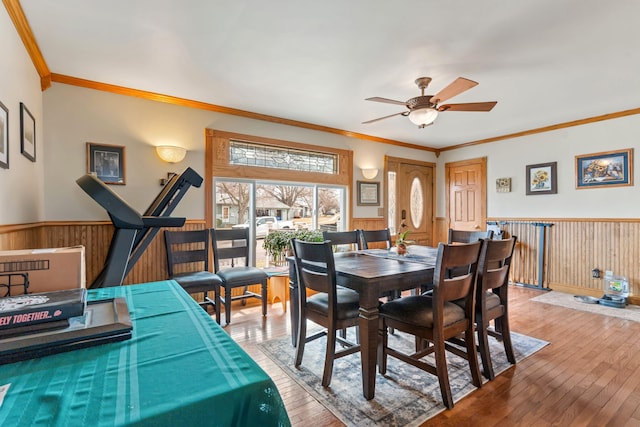 2030 12th Ave, Belle Fourche, SD 57717 - dining space with wainscoting, a ceiling fan, hardwood / wood-style flooring, ornamental molding, and wood walls