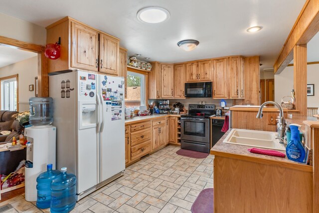 2030 12th Ave, Belle Fourche, SD 57717 - kitchen featuring stainless steel electric range oven, black microwave, white fridge with ice dispenser, a sink, and light countertops
