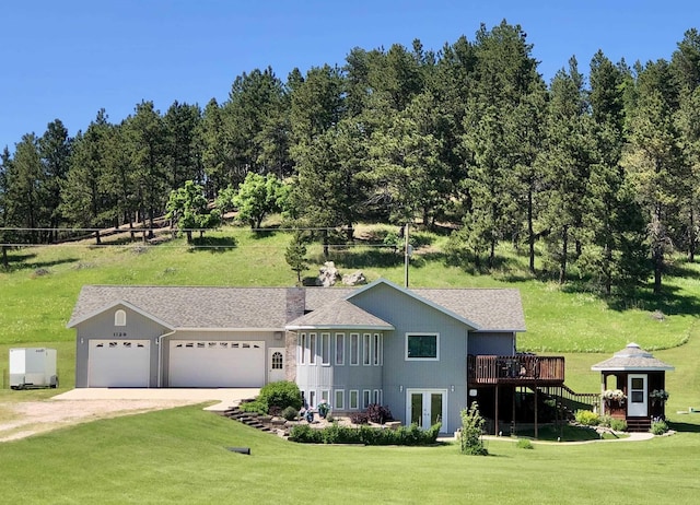 1129 Foothills Rd, Sturgis, SD 57785 - view of front facade featuring a front yard, french doors, a wooden deck, dirt driveway, and a garage