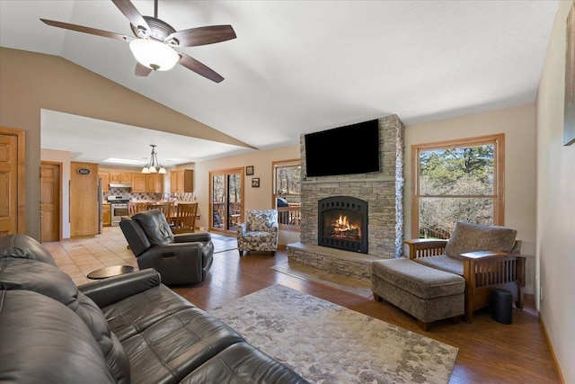 376 Lone Elk Rd, Spearfish, SD 57783 - living room featuring lofted ceiling, healthy amount of natural light, a fireplace, a ceiling fan, and light wood-type flooring