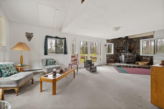 24227 Pine Grove Rd, Rapid City, SD 57702 - living room featuring a wood stove, carpet, healthy amount of natural light, and a baseboard heating unit