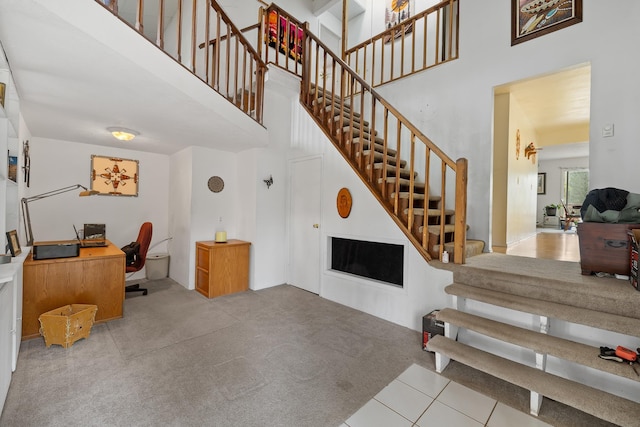 24227 Pine Grove Rd, Rapid City, SD 57702 - staircase featuring a high ceiling, carpet, and tile patterned flooring