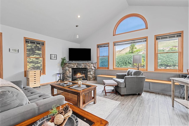 7725 Other, Rapid City, SD 57702 - living area featuring a stone fireplace, light wood-style floors, and high vaulted ceiling