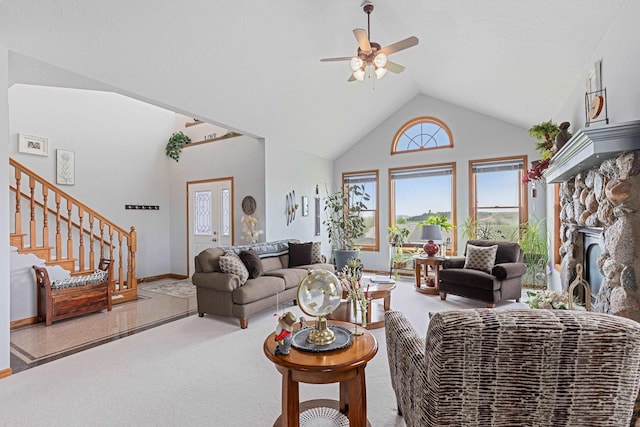 7725 Other, Rapid City, SD 57702 - living room with carpet flooring, ceiling fan, stairway, a stone fireplace, and high vaulted ceiling