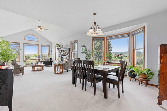 7725 Other, Rapid City, SD 57702 - dining area with light colored carpet, a chandelier, a ceiling fan, lofted ceiling, and a stone fireplace