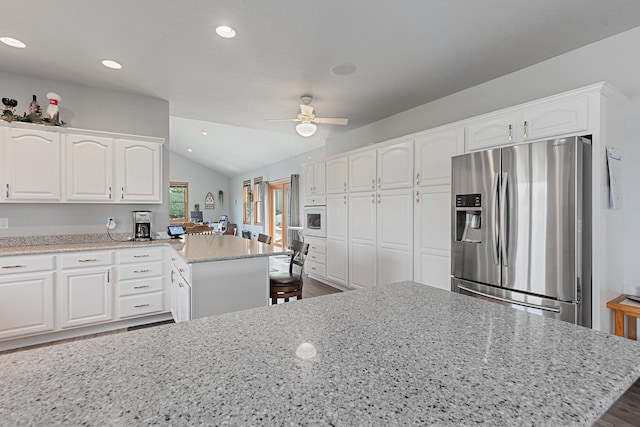 7725 Other, Rapid City, SD 57702 - kitchen featuring stainless steel fridge with ice dispenser, vaulted ceiling, light stone countertops, white cabinetry, and ceiling fan