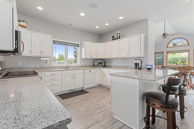 7725 Other, Rapid City, SD 57702 - kitchen featuring dishwasher, a sink, a peninsula, a breakfast bar, and white cabinets