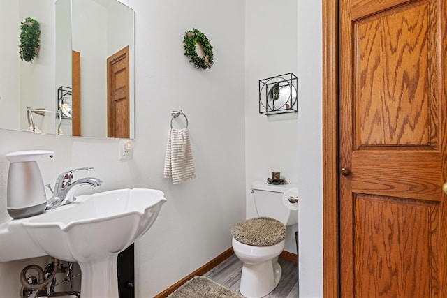 7725 Other, Rapid City, SD 57702 - half bath featuring toilet, wood finished floors, baseboards, and a sink