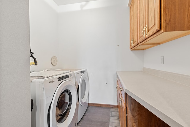 7725 Other, Rapid City, SD 57702 - washroom featuring cabinet space, separate washer and dryer, baseboards, and light wood-style flooring