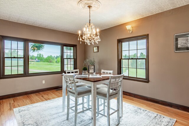 8510 Clarkson Rd, Rapid City, SD 57702 - dining area with plenty of natural light, light wood finished floors, a chandelier, baseboards, and a textured ceiling