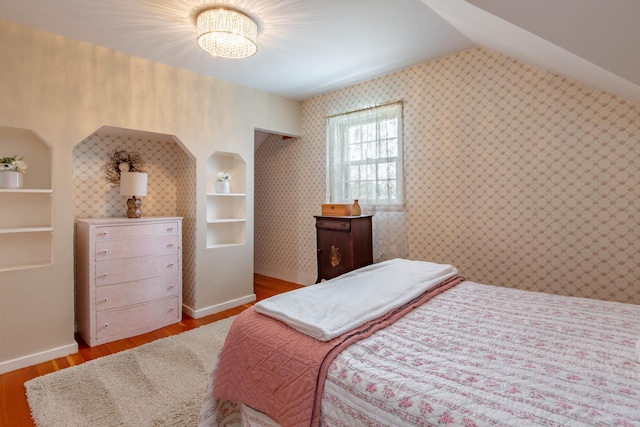 8510 Clarkson Rd, Rapid City, SD 57702 - bedroom featuring wood finished floors, wallpapered walls, lofted ceiling, and baseboards