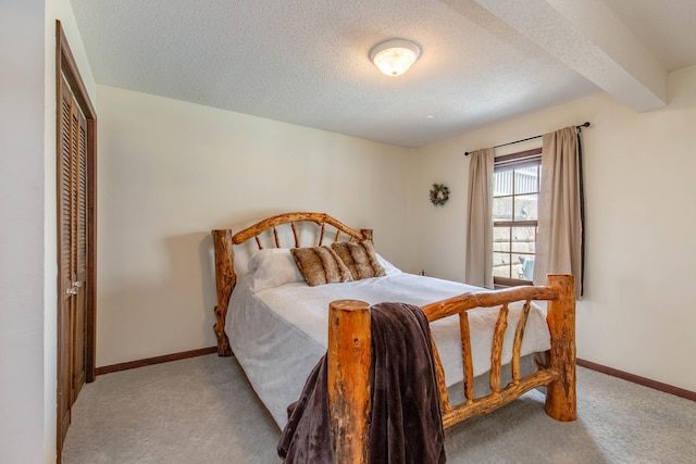 8510 Clarkson Rd, Rapid City, SD 57702 - carpeted bedroom featuring a textured ceiling, baseboards, a closet, and beam ceiling