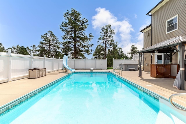 8510 Clarkson Rd, Rapid City, SD 57702 - view of pool with a hot tub, a patio, a fenced backyard, and a water slide