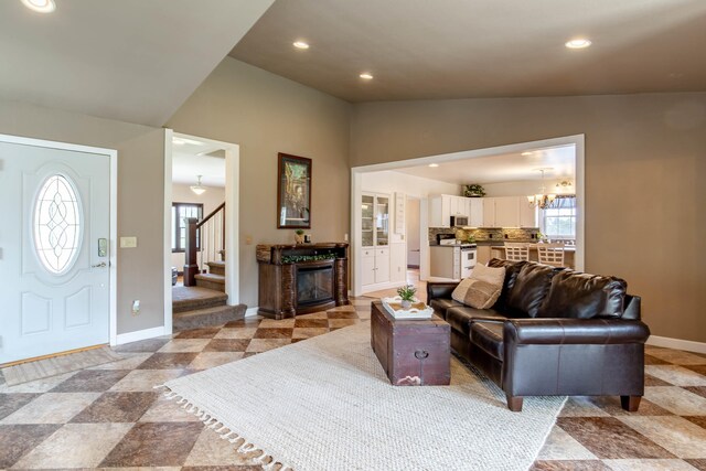 8510 Clarkson Rd, Rapid City, SD 57702 - living room with baseboards, lofted ceiling, recessed lighting, a chandelier, and a glass covered fireplace