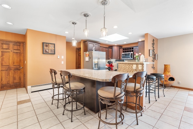 22994 Shields Rd, Rapid City, SD 57702 - kitchen with appliances with stainless steel finishes, light tile patterned floors, a peninsula, light stone countertops, and recessed lighting