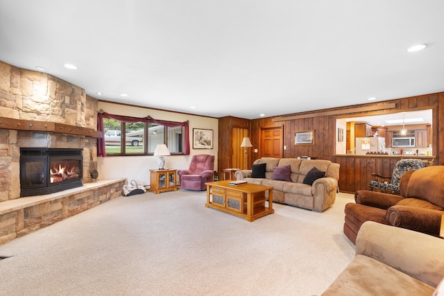22994 Shields Rd, Rapid City, SD 57702 - living room with carpet flooring, wooden walls, recessed lighting, a stone fireplace, and ornamental molding