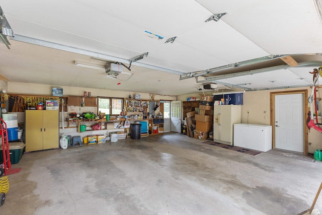 22994 Shields Rd, Rapid City, SD 57702 - garage featuring a garage door opener, refrigerator, and a workshop area