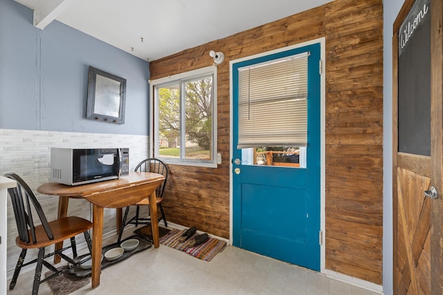 2101 Juniper Dr, Rapid City, SD 57702 - doorway to outside with an office area, wood walls, wainscoting, and tile patterned floors