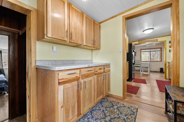 123 Gordon St, Custer, SD 57730 - kitchen featuring black fridge, light wood-style floors, light countertops, and crown molding