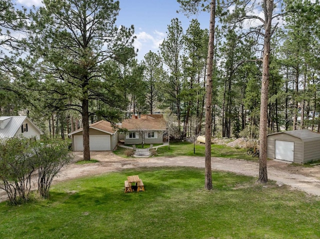 123 Gordon St, Custer, SD 57730 - view of green lawn with a detached garage, an outbuilding, and view of scattered trees