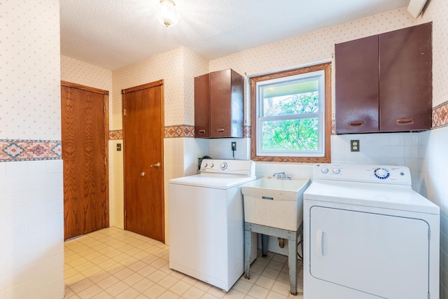 15630 Antelope Creek Rd, Rapid City, SD 57703 - laundry area with wallpapered walls, cabinet space, independent washer and dryer, tile walls, and light tile patterned flooring