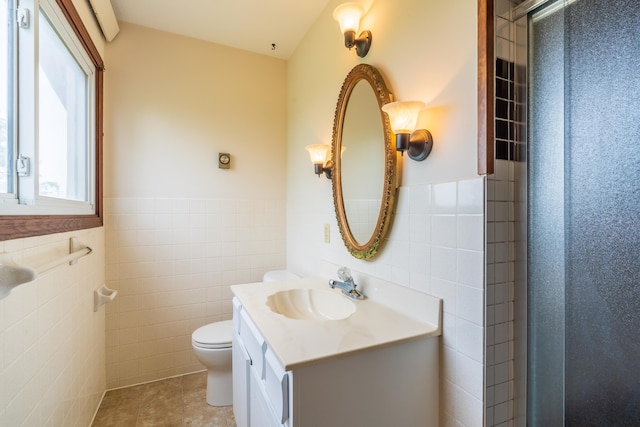 15630 Antelope Creek Rd, Rapid City, SD 57703 - full bath with tile walls, wainscoting, toilet, tile patterned floors, and vanity