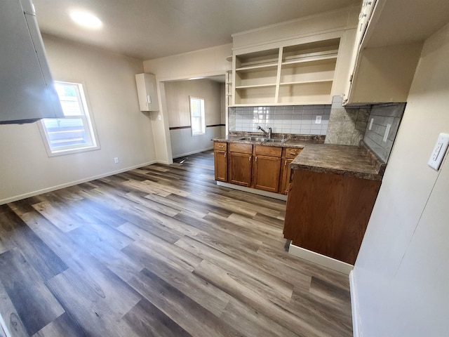 105 N Washington St, Edgemont, SD 57735 - kitchen with dark countertops, a sink, brown cabinets, backsplash, and dark wood-style floors