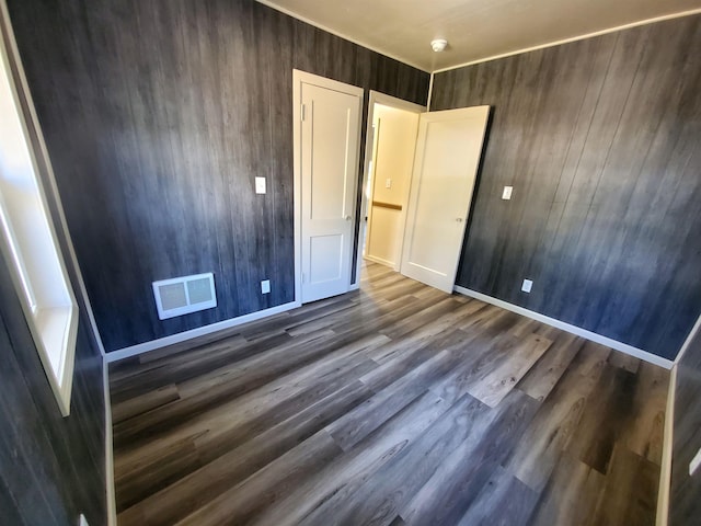 105 N Washington St, Edgemont, SD 57735 - unfurnished bedroom with wood finished floors, wood walls, and baseboards