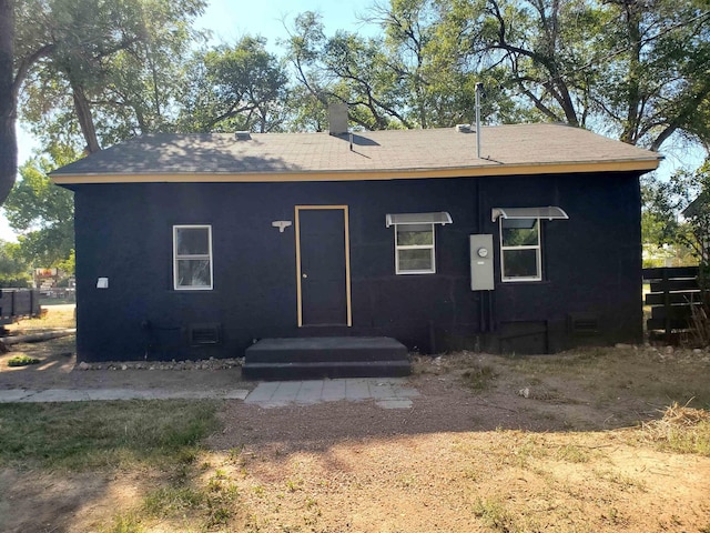 105 N Washington St, Edgemont, SD 57735 - back of property with a shingled roof, a chimney, and crawl space