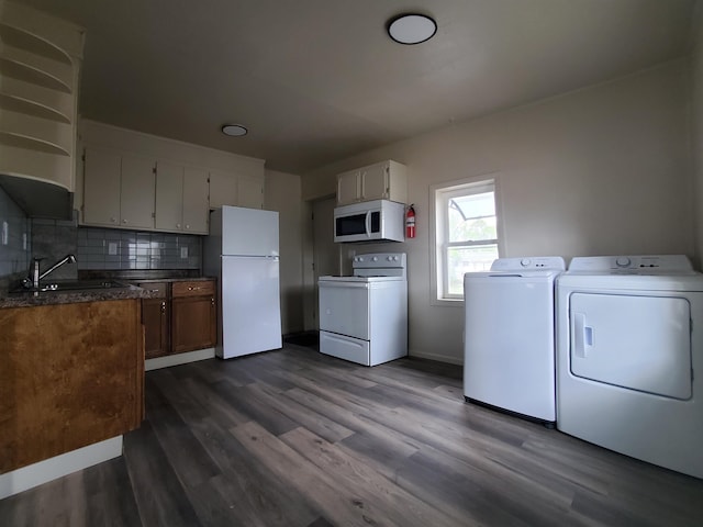 105 N Washington St, Edgemont, SD 57735 - kitchen featuring white appliances, washer and clothes dryer, a sink, dark countertops, and decorative backsplash