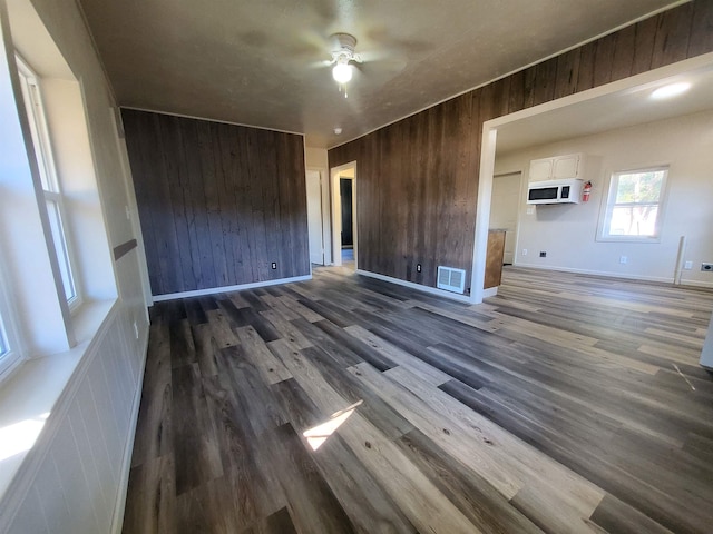 105 N Washington St, Edgemont, SD 57735 - empty room with wood walls, a ceiling fan, dark wood finished floors, and baseboards