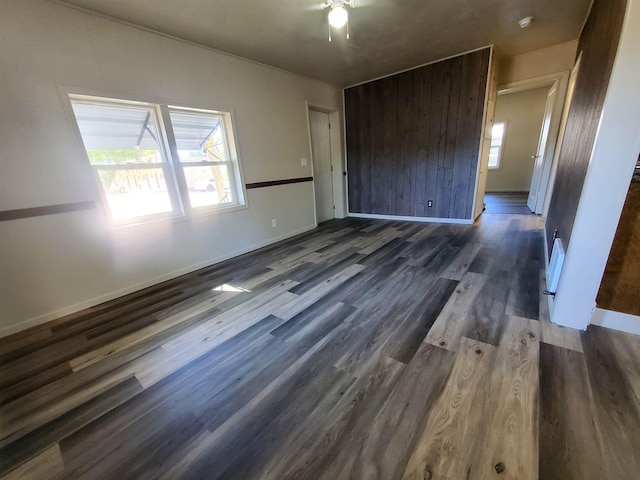 105 N Washington St, Edgemont, SD 57735 - unfurnished bedroom featuring dark wood-style floors, multiple windows, and baseboards