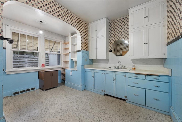 308 Main St, Deadwood, SD 57732 - kitchen with a sink, blue cabinets, light countertops, wallpapered walls, and open shelves