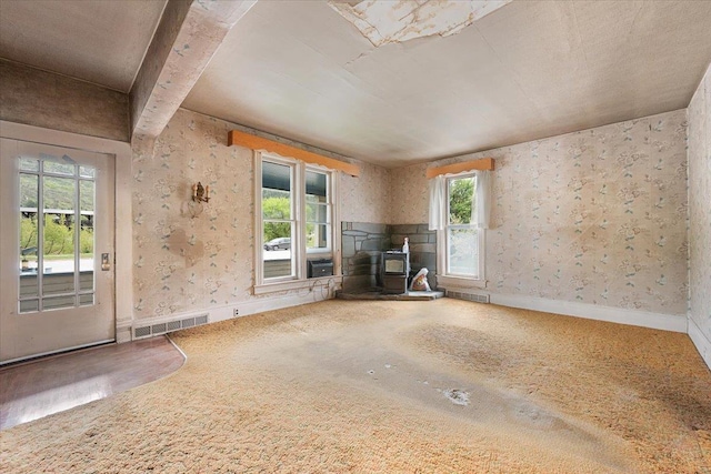 308 Main St, Deadwood, SD 57732 - unfurnished living room with a wood stove and baseboards