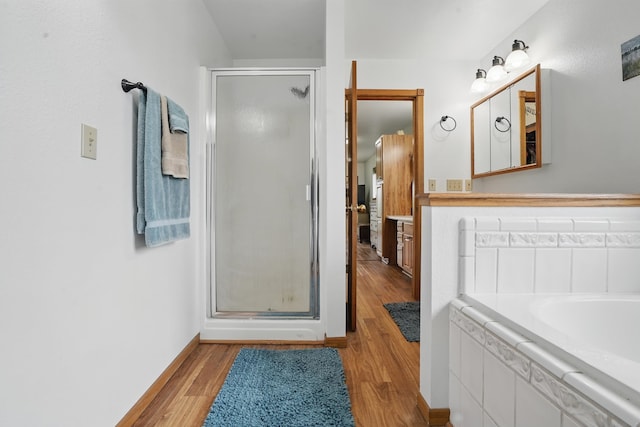 18977 Black Angus Ln, Belle Fourche, SD 57717 - bathroom with a stall shower, wood finished floors, and a bath
