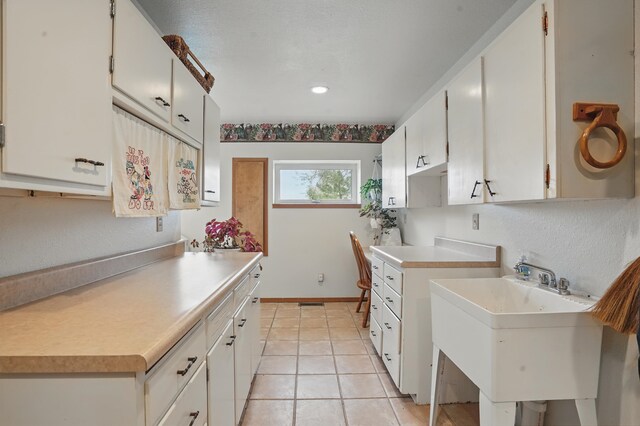 18977 Black Angus Ln, Belle Fourche, SD 57717 - kitchen with light tile patterned floors, light countertops, a sink, white cabinets, and recessed lighting