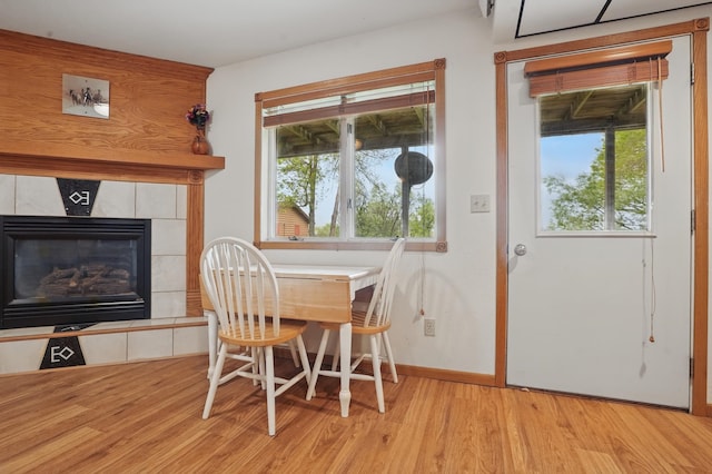 18977 Black Angus Ln, Belle Fourche, SD 57717 - dining room with wood finished floors, healthy amount of natural light, a tiled fireplace, and baseboards