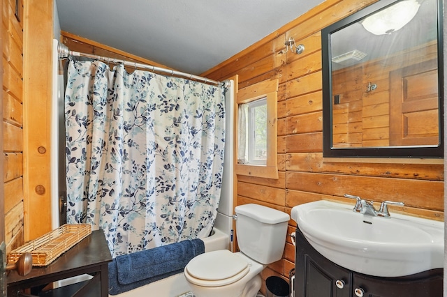 18977 Black Angus Ln, Belle Fourche, SD 57717 - bathroom featuring vanity, wooden walls, shower / tub combo, and toilet