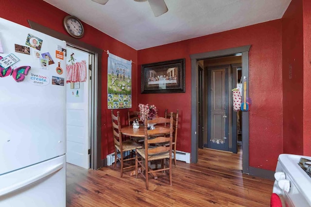 1007 Elkhorn St, Belle Fourche, SD 57717 - dining room with wood finished floors, baseboard heating, and a ceiling fan