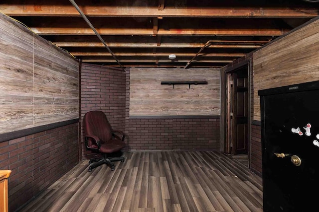 1007 Elkhorn St, Belle Fourche, SD 57717 - basement with wood walls, wood finished floors, and brick wall