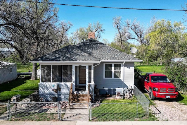1007 Elkhorn St, Belle Fourche, SD 57717 - view of front of property with a shingled roof, a sunroom, a gate, and a chimney