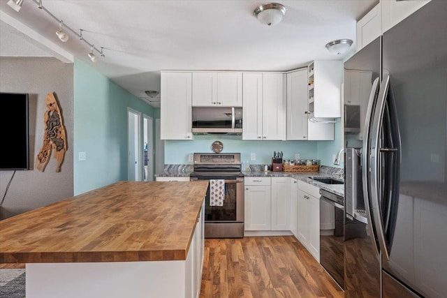 2921 1st Ave, Sturgis, SD 57785 - kitchen featuring stainless steel appliances, wooden counters, a sink, light wood-style flooring, and open shelves