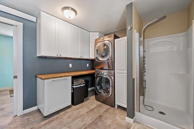 2921 1st Ave, Sturgis, SD 57785 - washroom featuring stacked washer / drying machine, light wood-type flooring, and baseboards