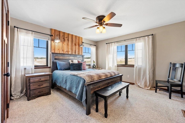 10226 Buena Vista Ln, Belle Fourche, SD 57717 - bedroom featuring light colored carpet, a ceiling fan, and wood walls