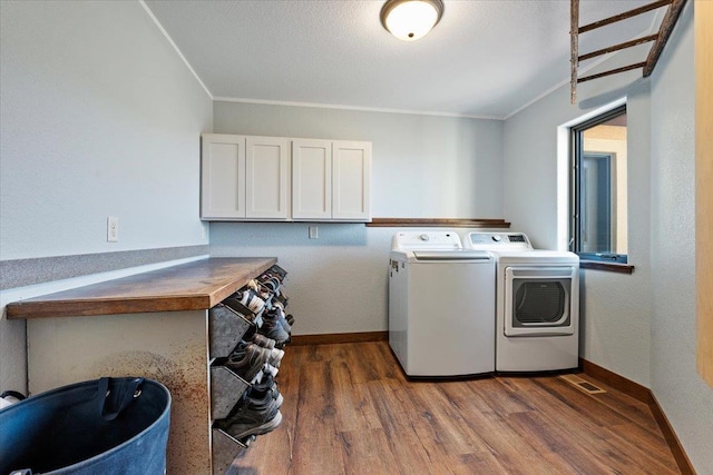 10226 Buena Vista Ln, Belle Fourche, SD 57717 - laundry room with cabinet space, washing machine and dryer, wood finished floors, ornamental molding, and baseboards