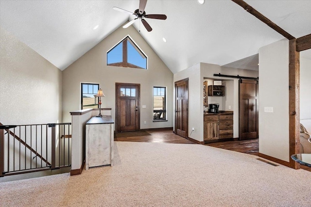 10226 Buena Vista Ln, Belle Fourche, SD 57717 - carpeted foyer entrance with a barn door, high vaulted ceiling, baseboards, and ceiling fan